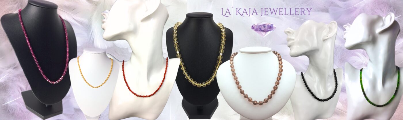 Edelstein Halsketten von La`Kaja präsentiert auf Büsten und Federn als Hintergrund