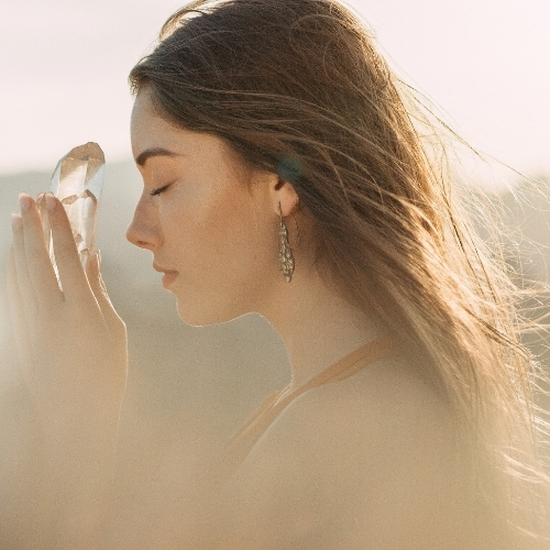 Edelsteinschmuck von La`Kaja Frau mit Bergkristallspitze in den Händen Steinheilkunde