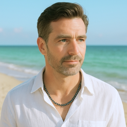 Edelsteinschmuck von La`Kaja Jewellery Mann mit Hämatit Halskette am Strand